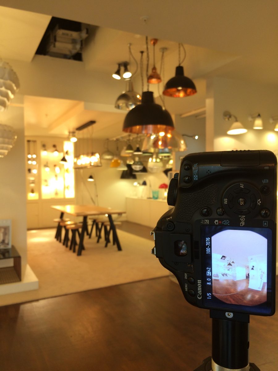 A fisheye frame on the camera screen during a shoot in a lighting showroom